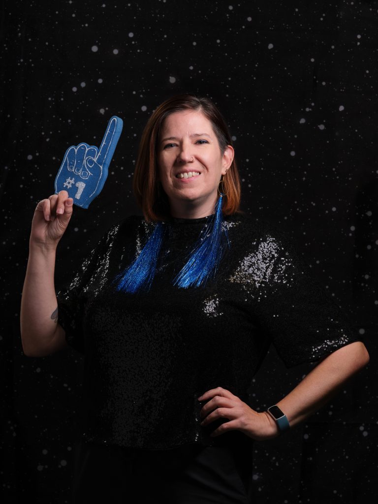 Stabby is holding up a giant blue foam finger