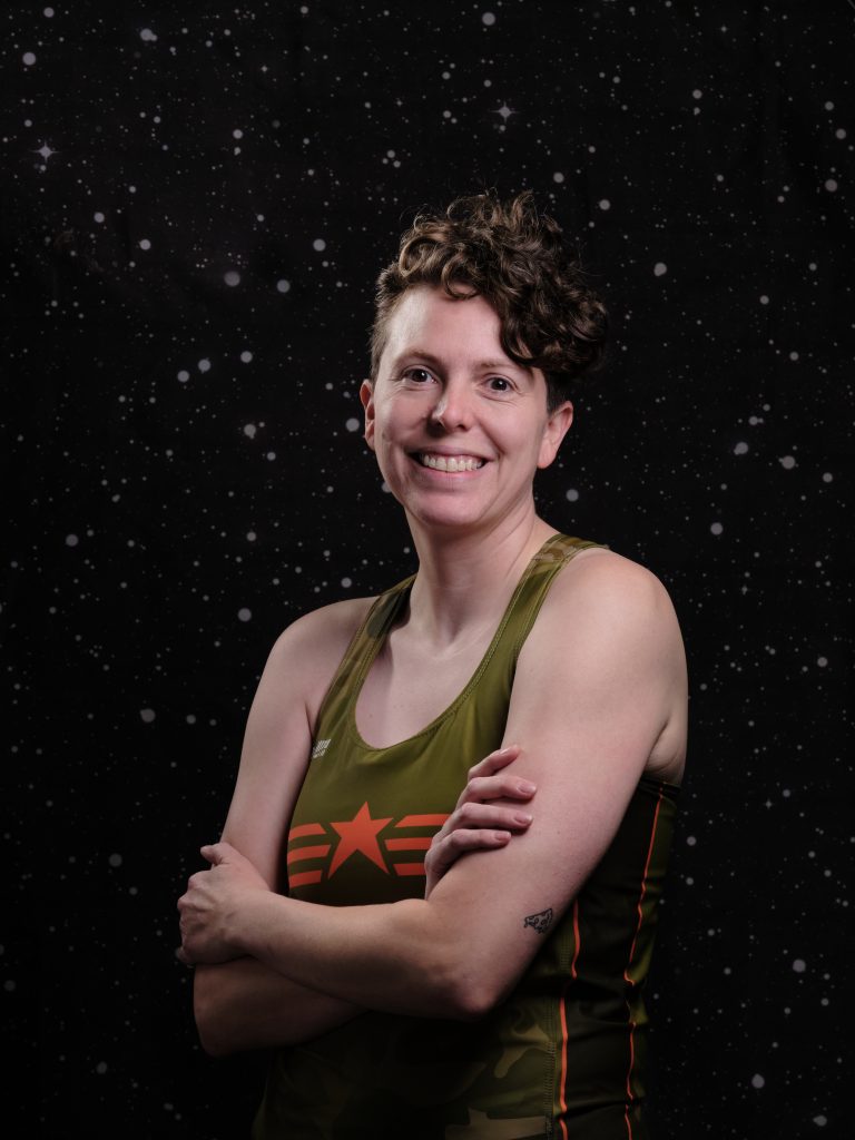 Karma is smiling and crossing their arms