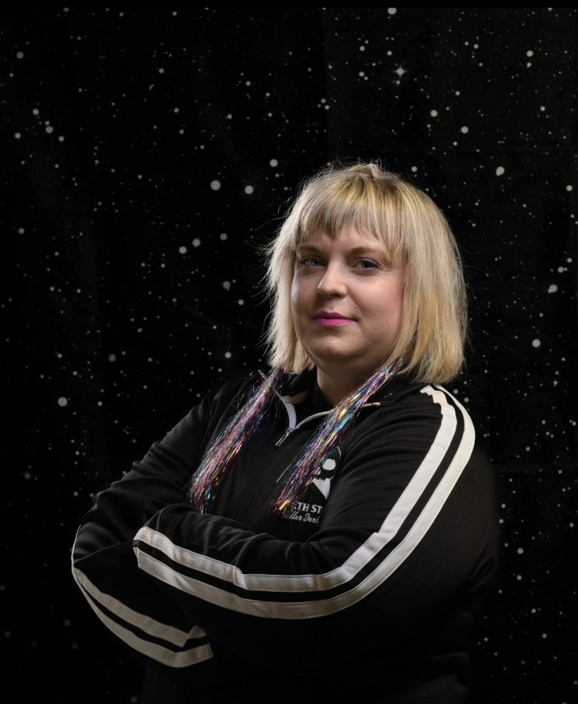 Pittie is smiling and crossing her arms